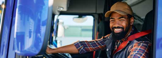 Trucker smiling and driving a truck